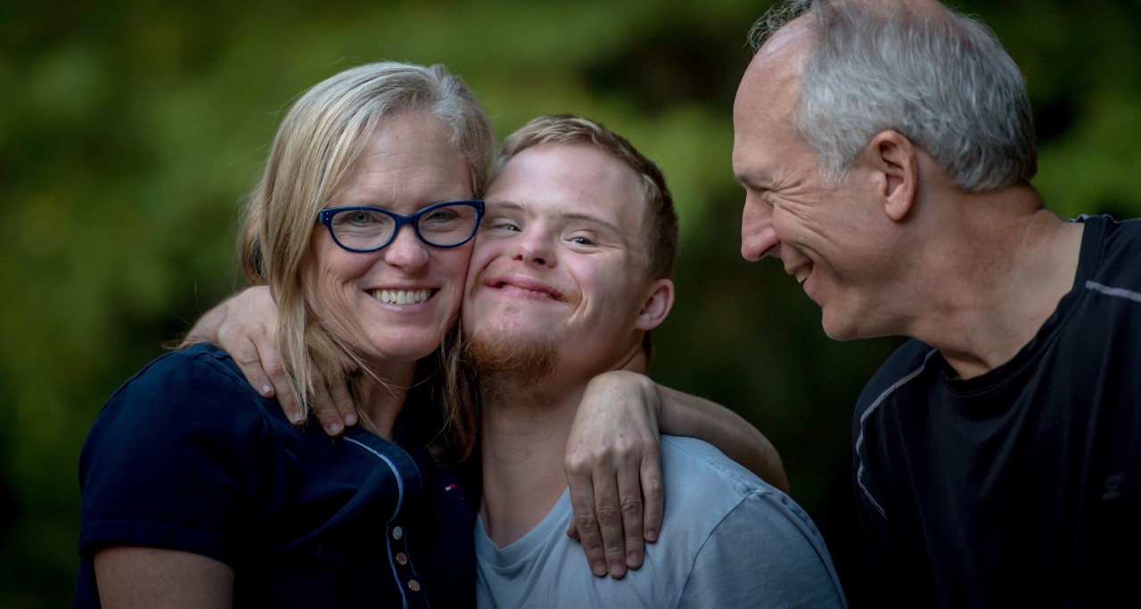 A photo of a man, woman and young person smiling outdoors