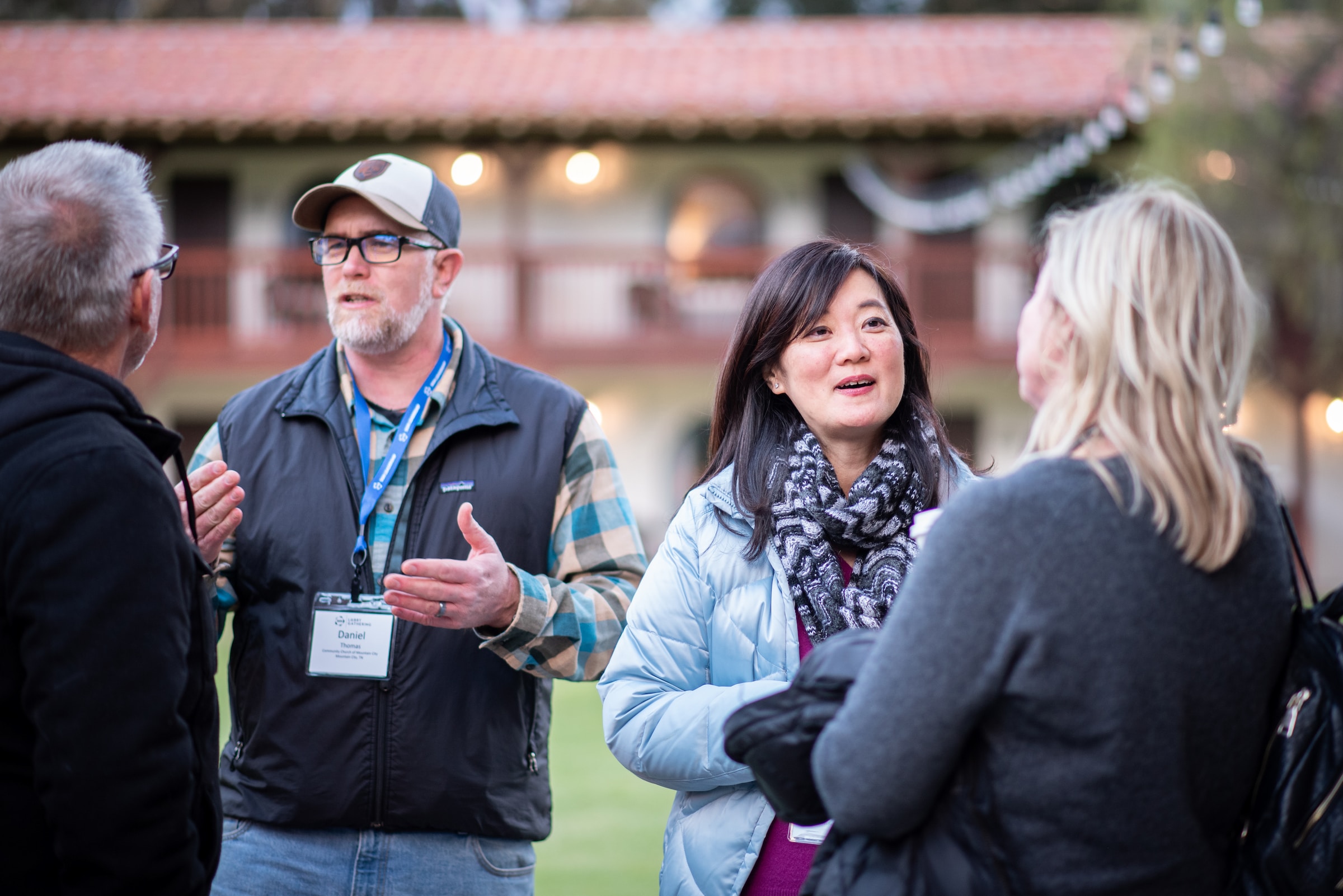 Photo of a man and a women each talking to a man and woman with their back turned.